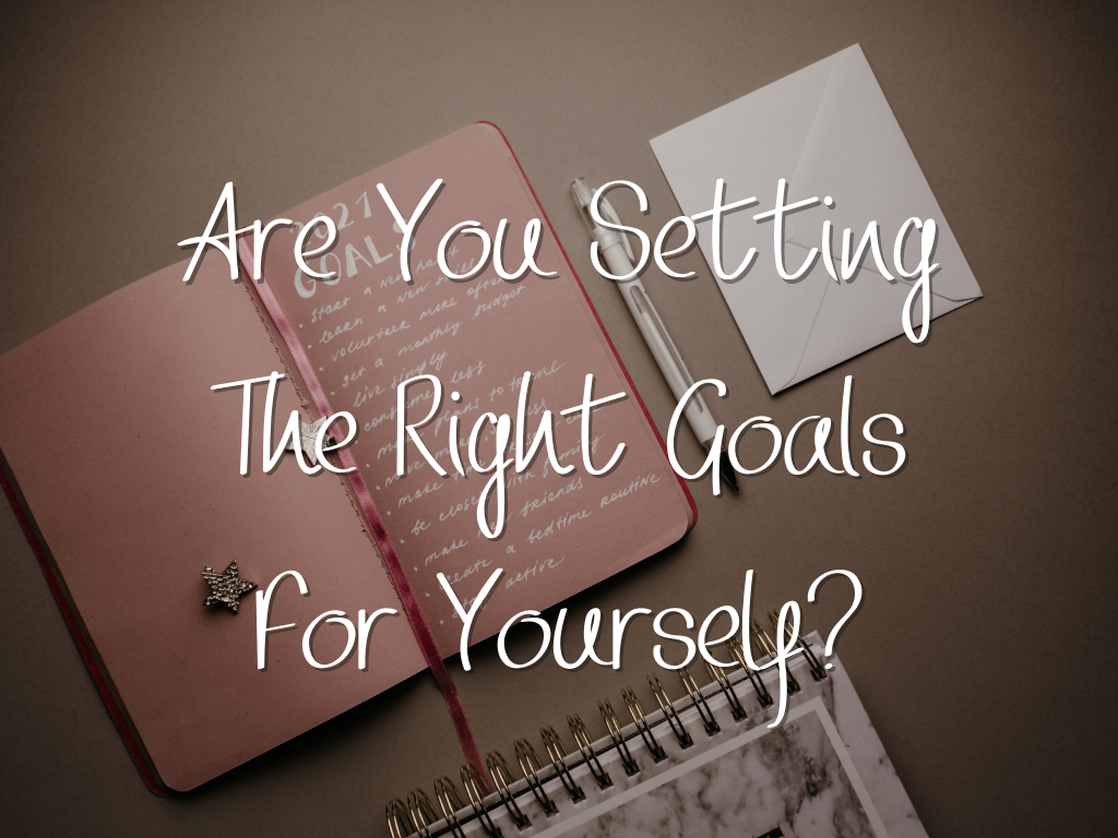 a pink notebook with a list of goals.