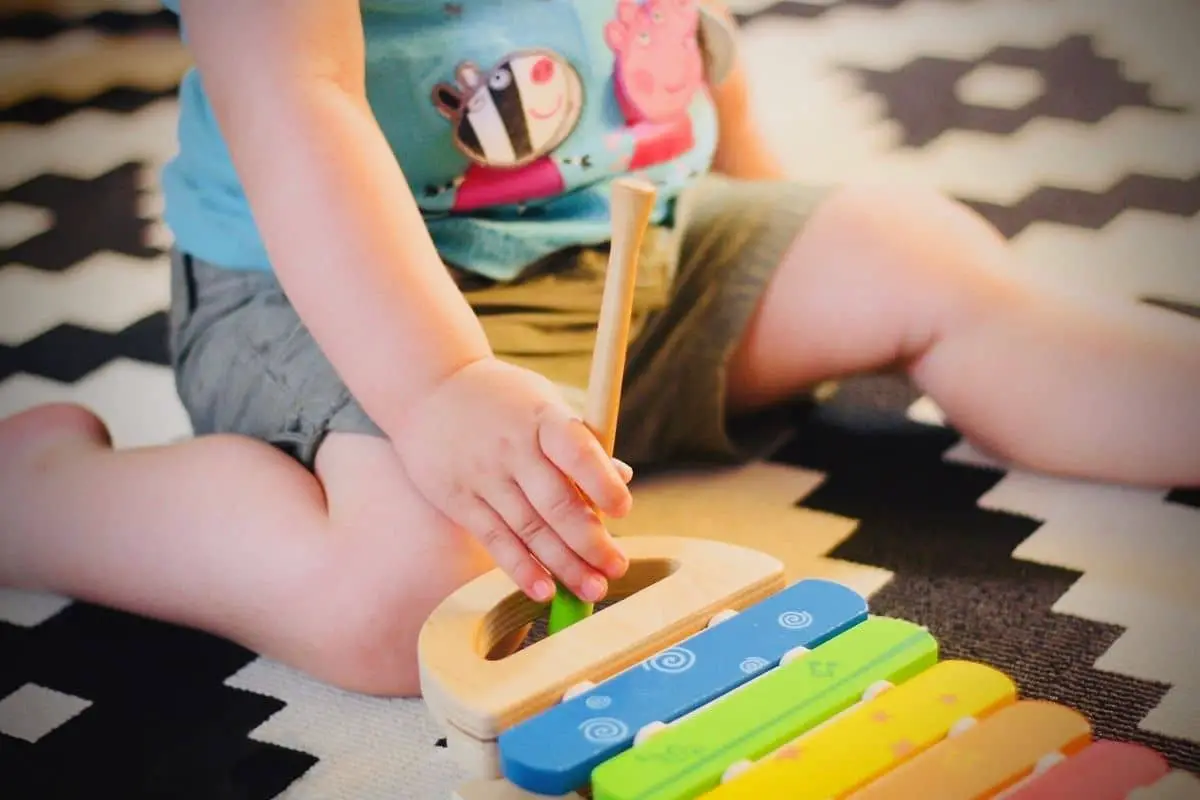 toddler playing on a xylophone