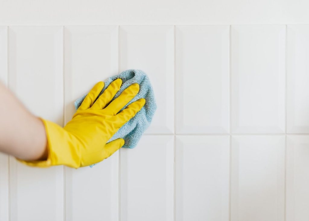 Scrubbing the tile as part of the household chores list.
