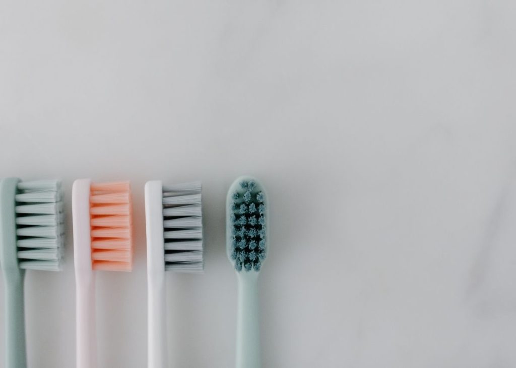 Pastel colored toothbrushes in a row.