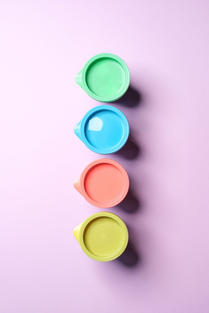 Green, blue, pink, and yellow lids with a purple background.